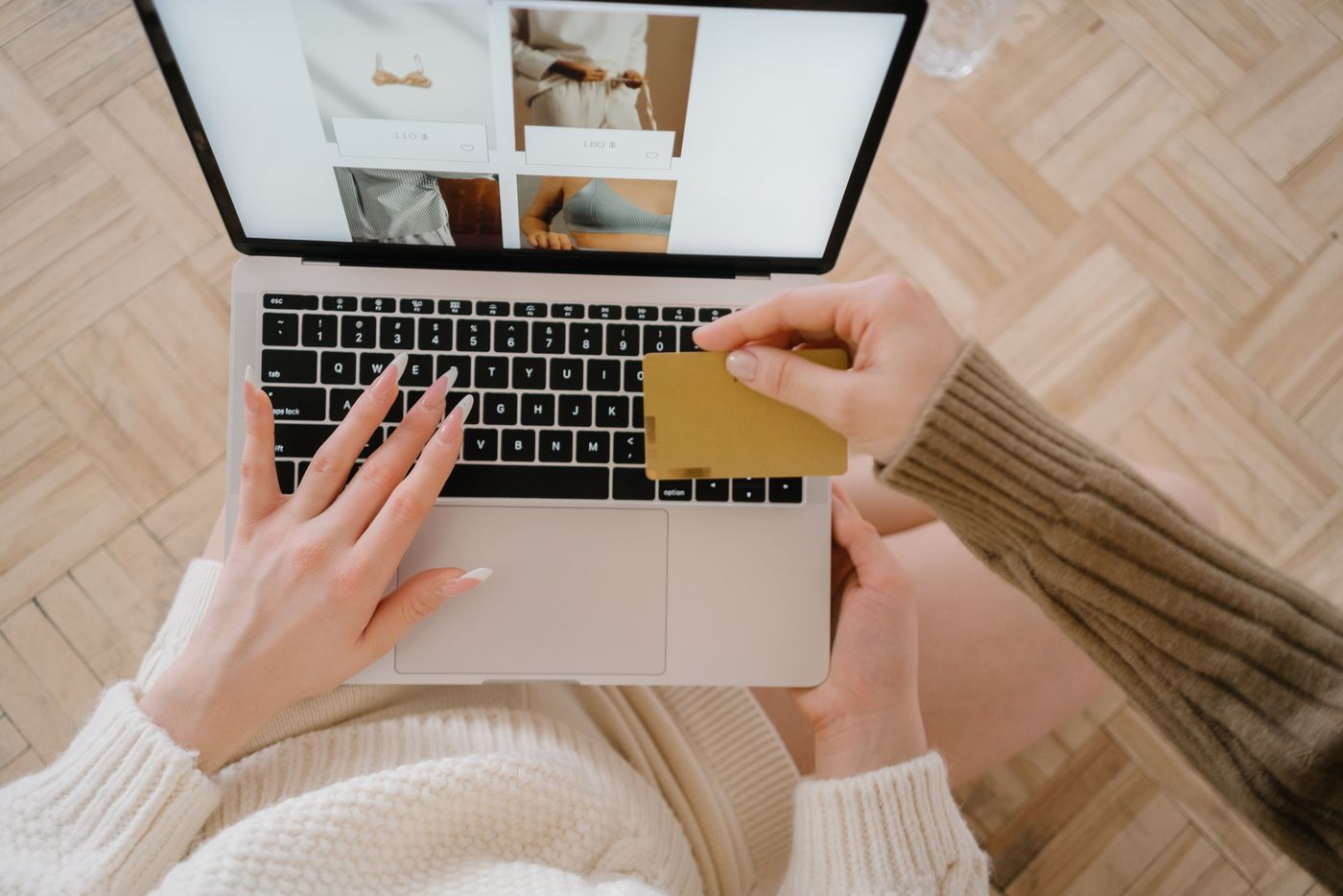 Overhead view of a shopper using a laptop and holding a payment card